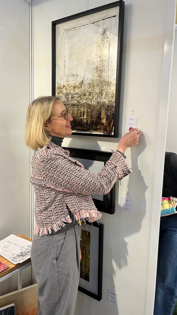 Marina Elizalde colgando una obra en su stand