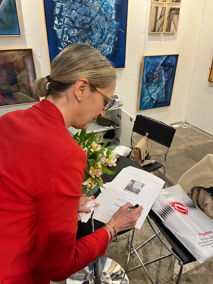 Marina Elizalde firmando un catálogo en su stand