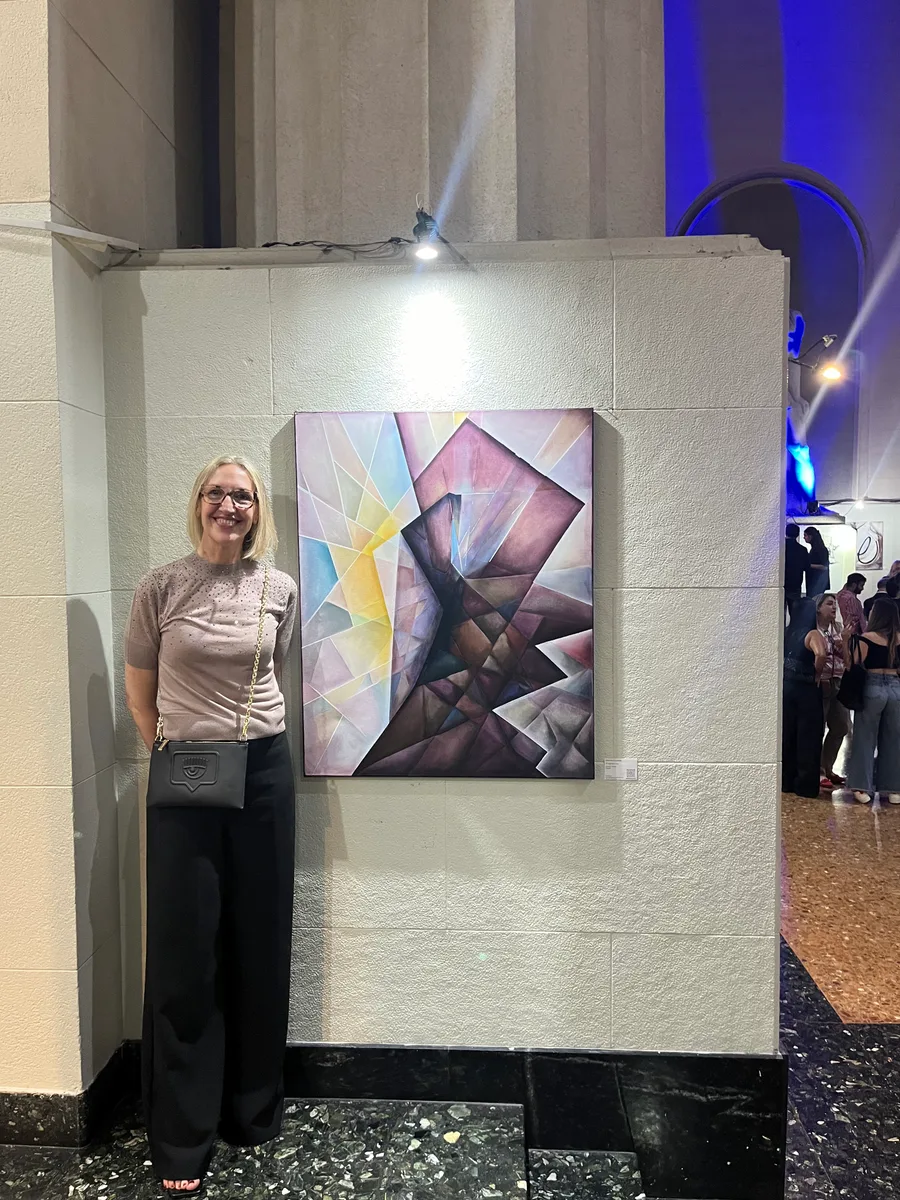 Marina Elizalde junto a una pintura en tonos violetas