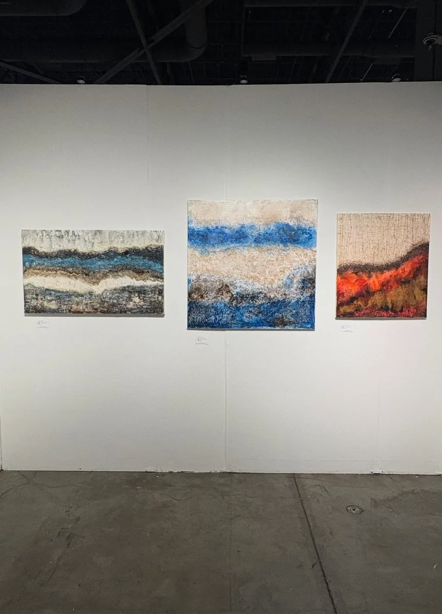 Tres pinturas de Marina Elizalde en una pared de la Seattle Art Fair